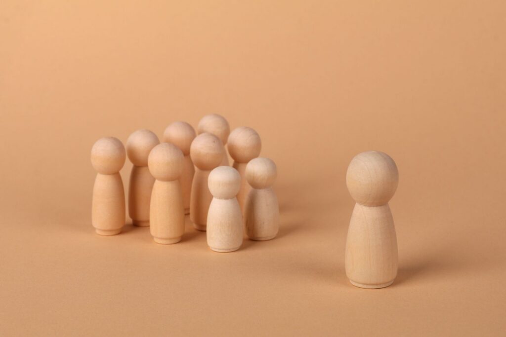 Figures en bois minimalistes symbolisant les dynamiques sociales et l'isolement