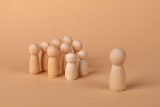 Figures en bois minimalistes symbolisant les dynamiques sociales et l'isolement