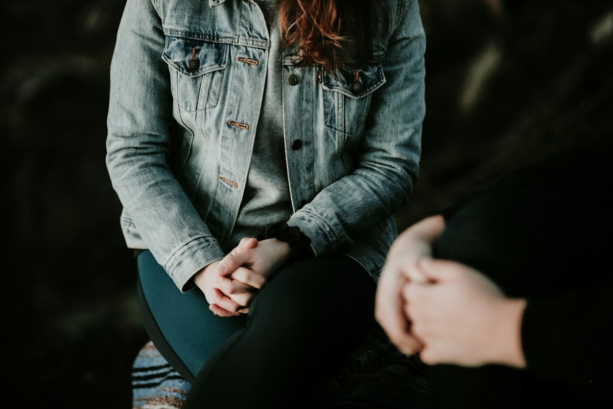 Femme assise et portant une veste de denim
