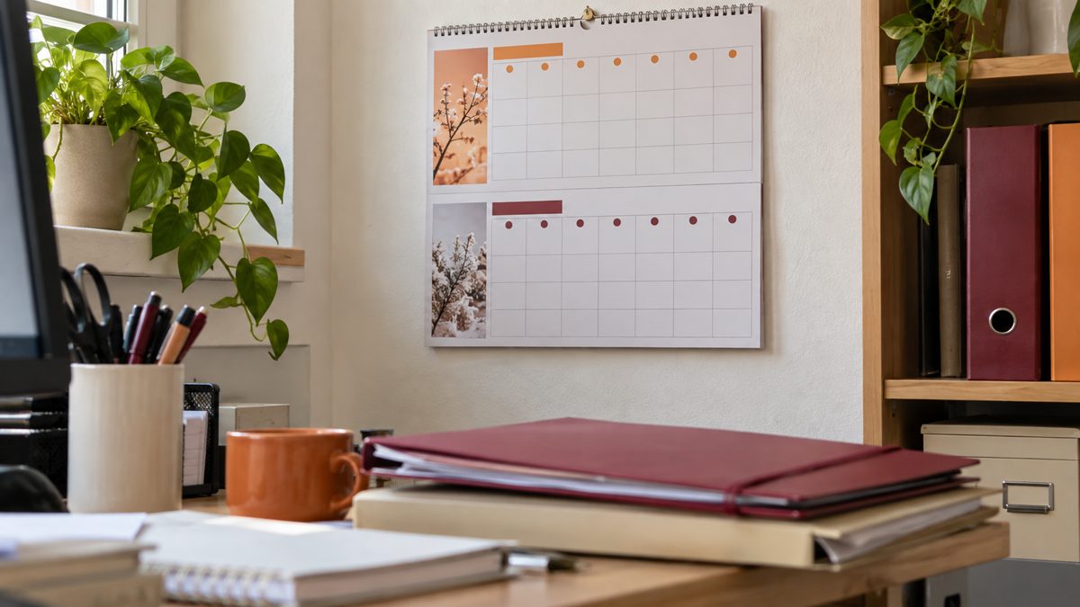 Calendrier mural sur bureau avec dossiers fermés en premier plan